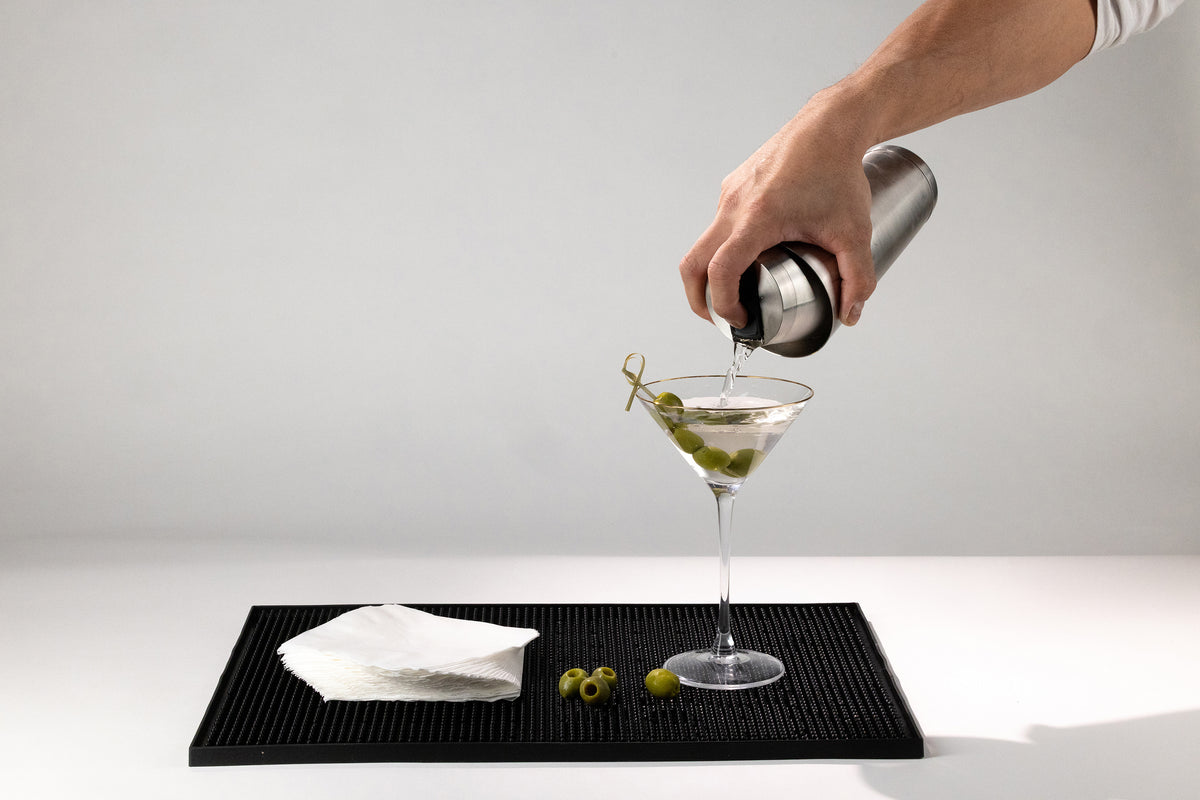 Bartender pouring a martini one-handed from the Speed Tin cocktail shaker with built-in strainer