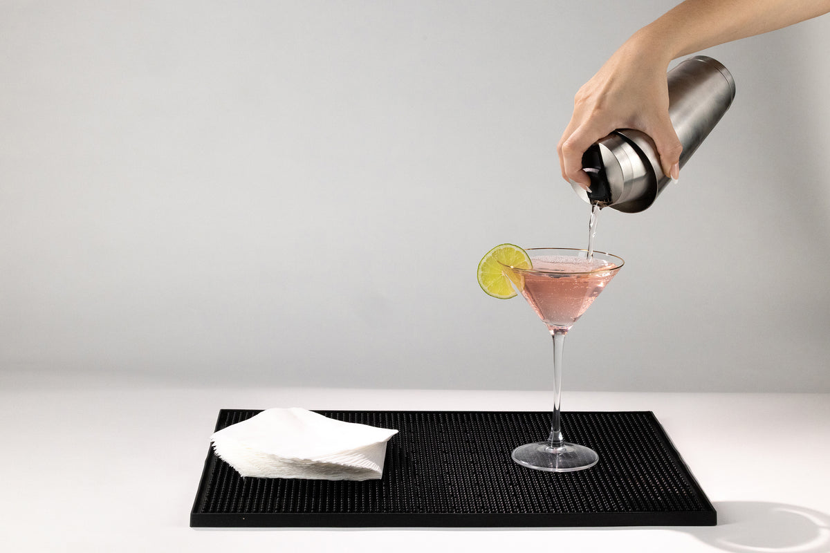 Pouring a cosmopolitan one-handed from the Speed Tin cocktail shaker into a martini glass